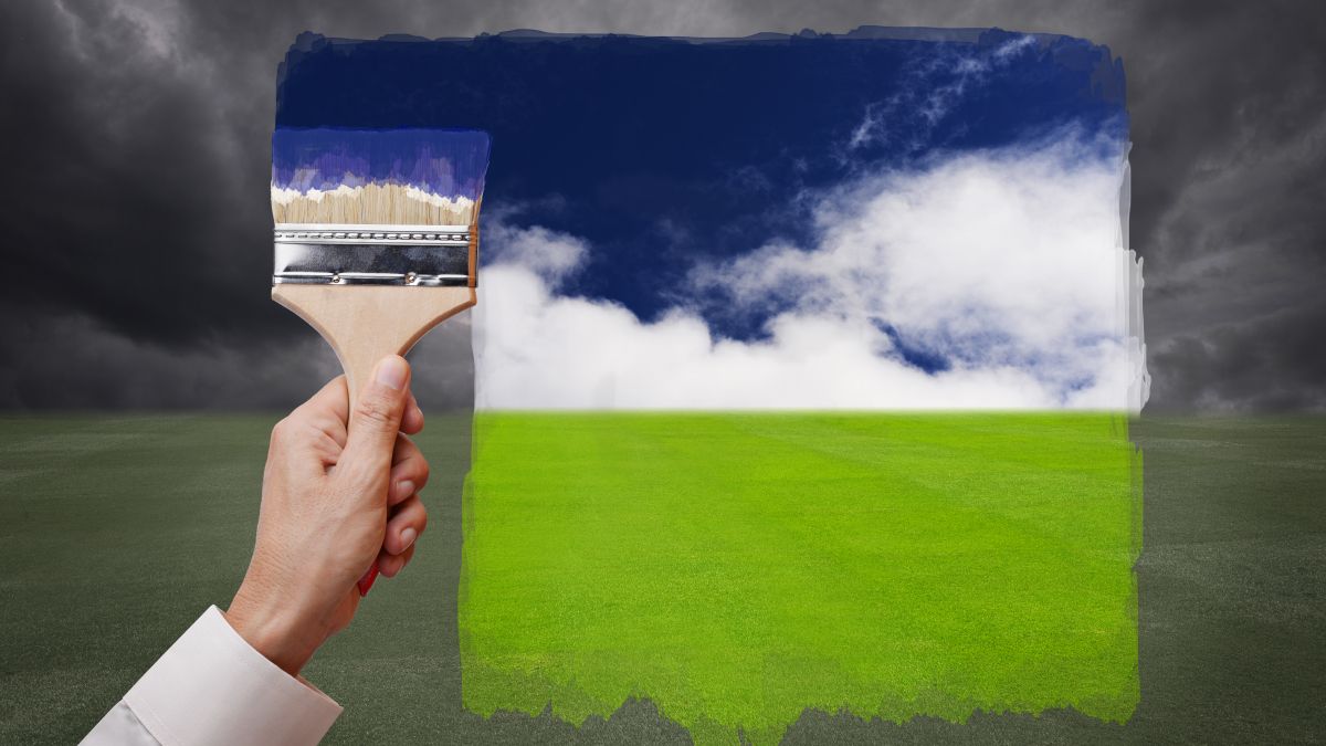 hand holding paintbrush over colorful photo